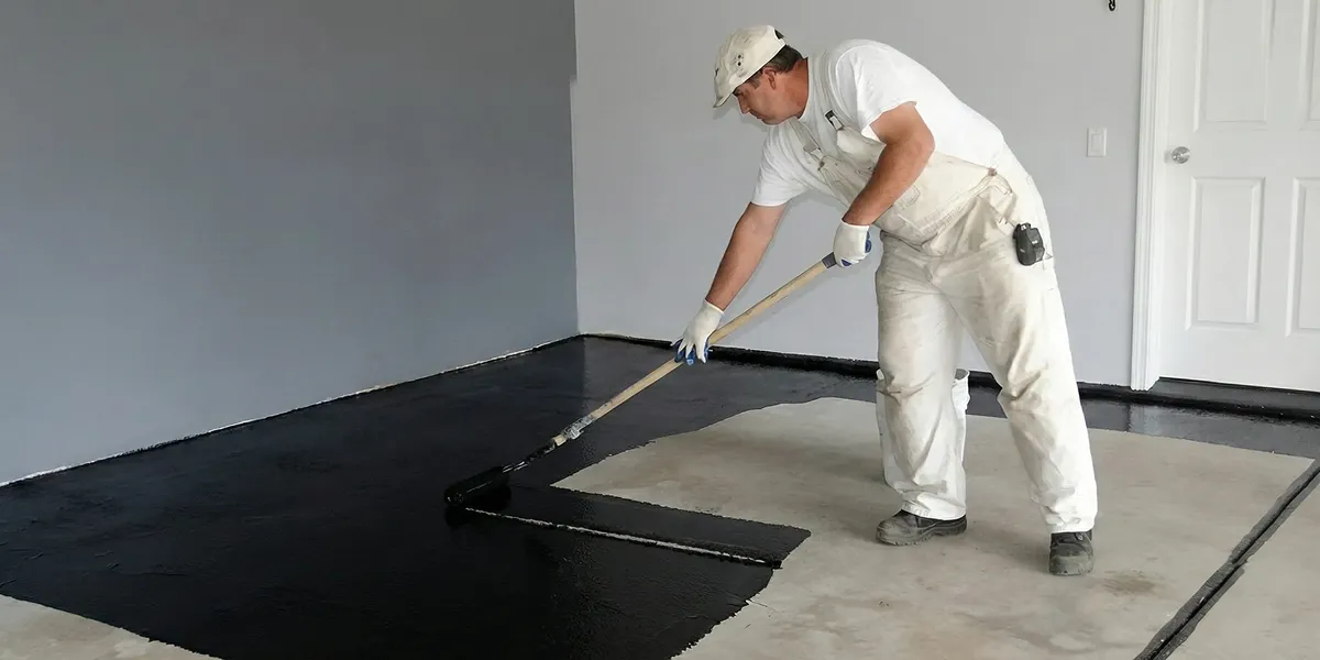 basement waterproofing professional applying waterproof coating to protect a basement floor in Phoenix, AZ