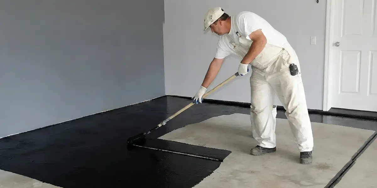 basement waterproofing professional applying waterproof coating to protect a basement floor in Phoenix, AZ